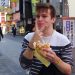 Jayden Thomas holds up a peace sign while eating food.